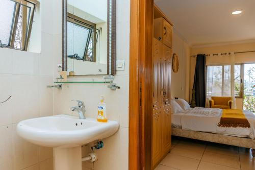 a bathroom with a sink and a bedroom at Stunning 3-Bed House in Kigali in Kigali