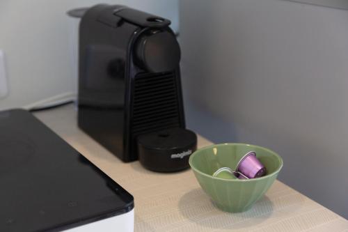 - un four micro-ondes et un bol vert sur un comptoir dans l'établissement Studio vue magique proche Locronan, à Plogonnec