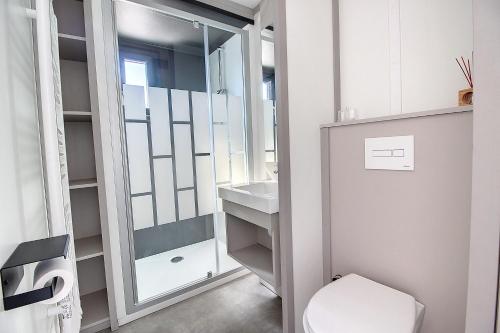 La salle de bains est pourvue de toilettes et d'un lavabo. dans l'établissement Le Chalet d'Angel, à Jullouville