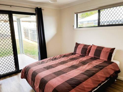 1 dormitorio con 1 cama en una habitación con ventanas en Stay at Mandi’s, en Kingston