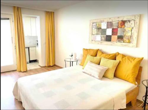 a bedroom with a large white bed with yellow pillows at Studio next to Karlsplatz/Karlskirche in Vienna