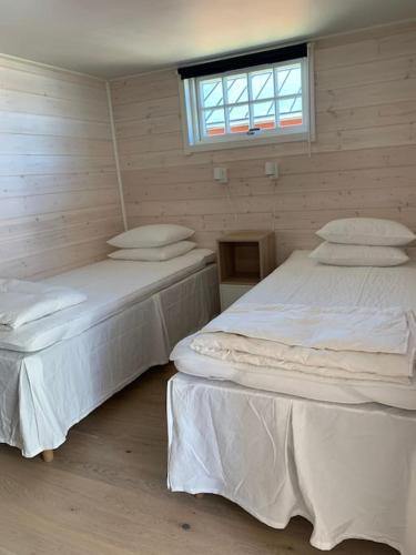 two twin beds in a room with a window at Lyxiga stugor med sjöutsikt in Söderköping