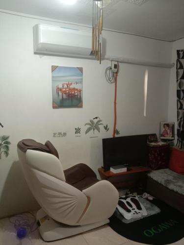 a living room with a white chair and a television at homesweethome 