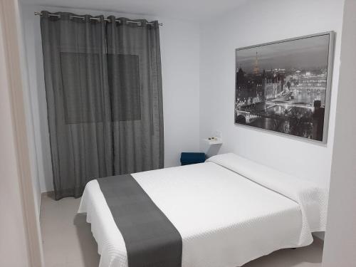a bedroom with a white bed and a window at Apartamento Rota in Rota