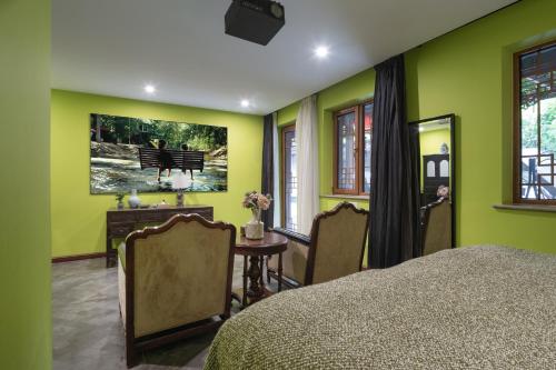 a bedroom with green walls and a table and chairs at Hotel Cote Cour Deductive Beijing - Quadrangle close to Tiananmen Square & Forbidden City & Nanluoguxiang, Walk to Wangfujing, English speaking, Free WiFi, Free Laundry, Free Wonton & Noodles with Tour ticket service, Free selfies with ancient costume in Beijing
