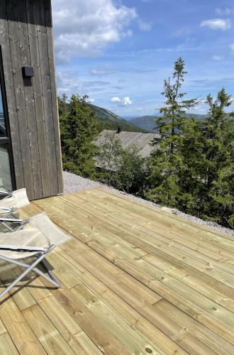 a wooden deck with a view of the mountains at Stylish cabin at Lifjell with jacuzzi and sauna in Bø