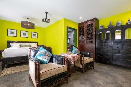 a yellow bedroom with a bed and two chairs at Hotel Cote Cour Deductive Beijing - Quadrangle close to Tiananmen Square & Forbidden City & Nanluoguxiang, Walk to Wangfujing, English speaking, Free WiFi, Free Laundry, Free Wonton & Noodles with Tour ticket service, Free selfies with ancient costume in Beijing