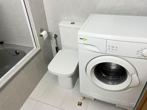 a bathroom with a washing machine and a toilet at Espacio ideal en la Playa in Oropesa del Mar