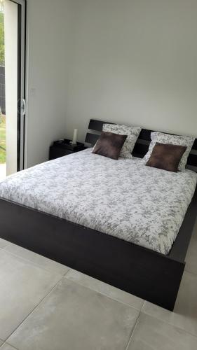 a bed in a bedroom with a black frame at Chambre d'hôte, Au pays de cocagne ! in Saint-Lieux-lès-Lavaur