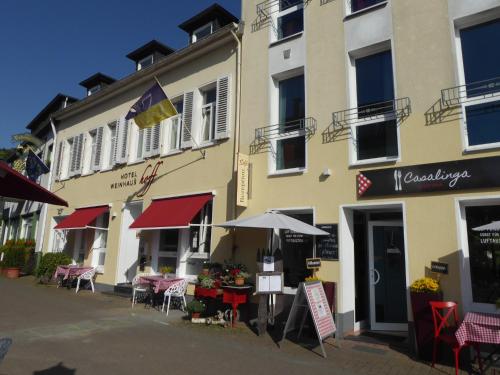 a building with tables and umbrellas in front of it at Hotel Weinhaus Hoff in Bad Honnef am Rhein