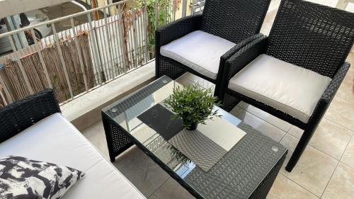 a patio with two chairs and a table with a plant at Sunny Peraia Apartment in Perea