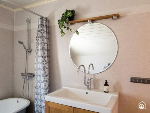 La salle de bains est pourvue d'un lavabo et d'un miroir. dans l'établissement Rustic Villa in Central Piteå, à Piteå