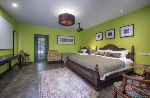 a bedroom with green walls and a bed and a piano at Hotel Cote Cour Deductive Beijing - Quadrangle close to Tiananmen Square & Forbidden City & Nanluoguxiang, Walk to Wangfujing, English speaking, Free WiFi, Free Laundry, Free Wonton & Noodles with Tour ticket service, Free selfies with ancient costume in Beijing
