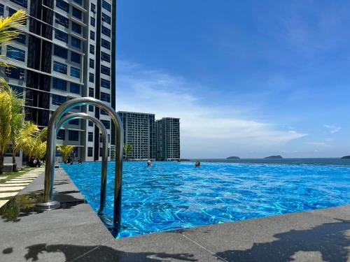 a large blue swimming pool next to tall buildings at J&J WALK lN SUMMER JESSELTON QUAY SURIA SABAH, IMAGO, CITY MALL 亞庇晴文旅 in Kota Kinabalu