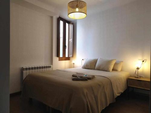 um quarto com uma grande cama branca e uma janela em Apartamentos casa memé em Mora de Rubielos
