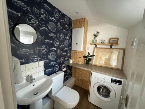 a bathroom with a sink and a washing machine at Cleethorpes - New 2 Bedroom house close to beach in Cleethorpes