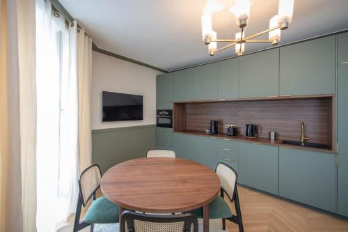 een eetkamer met een houten tafel en stoelen bij Bon Marche - Charming apartment in Parijs