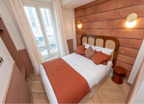 een slaapkamer met een bed met kussens en een raam bij Bon Marche - Charming apartment in Parijs