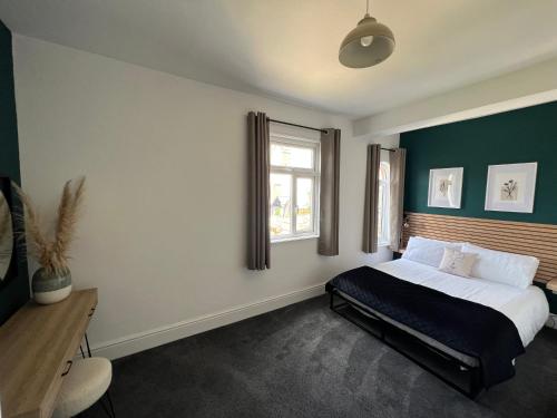a bedroom with a large bed and a window at Cleethorpes - New 2 Bedroom house close to beach in Cleethorpes