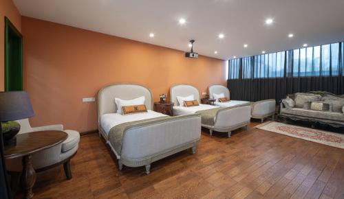 a room with three beds and a couch at Hotel Cote Cour Deductive Beijing - Quadrangle close to Tiananmen Square & Forbidden City & Nanluoguxiang, Walk to Wangfujing, English speaking, Free WiFi, Free Laundry, Free Wonton & Noodles with Tour ticket service, Free selfies with ancient costume in Beijing