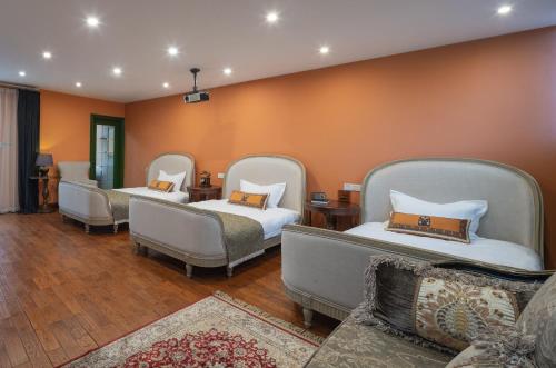 a room with three beds and a couch at Hotel Cote Cour Deductive Beijing - Quadrangle close to Tiananmen Square & Forbidden City & Nanluoguxiang, Walk to Wangfujing, English speaking, Free WiFi, Free Laundry, Free Wonton & Noodles with Tour ticket service, Free selfies with ancient costume in Beijing