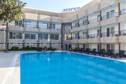 a large swimming pool in front of a hotel at Ayapam Hotel in Pamukkale