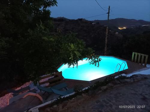 una gran piscina en un patio por la noche en Casa rural con piscina, en Torre de Benagalbón