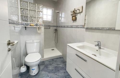 a white bathroom with a toilet and a sink at Azul Cómodo, bonito y céntrico in Calpe