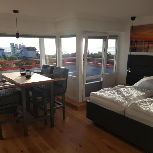 a bedroom with a bed and a table and chairs at LITTLE SKYSUITE Terrassenhaus W 94 in Cuxhaven