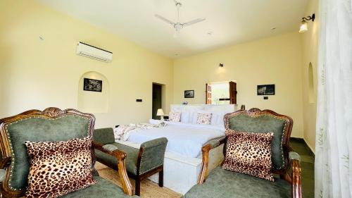 una camera con un letto e due sedie di Kutani Bagh - Best Hotel in Sariska National Park a Tehla