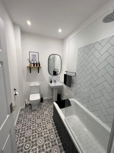 a bathroom with a tub and a toilet and a sink at Cleethorpes - 2 Bedroom Beach House in Cleethorpes