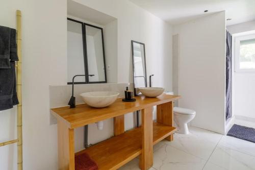 a bathroom with two sinks on a wooden counter at La Maison Coublandine in Coublanc
