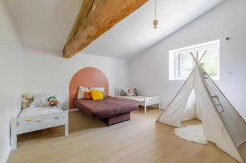 a room with a bed and a play tent at La Maison Coublandine in Coublanc