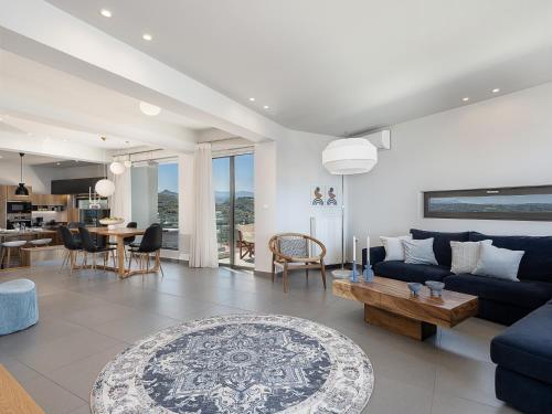 a living room with a blue couch and a table at Alectrona Living Crete, Villa Ãcro in Plataniás