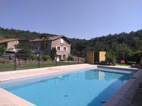 una gran piscina azul frente a una casa en Domaine de Minodier - Gite 6 pers. (Chez Maryline), en Ardoix