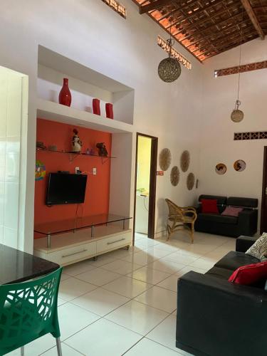 a living room with a couch and a tv at Sol Hostel & Pousada Maragogi in Maragogi