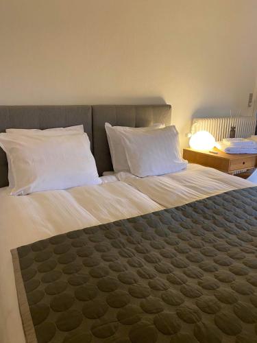 a bedroom with a large bed with white sheets and pillows at Unik BnB midt i byen in Herning