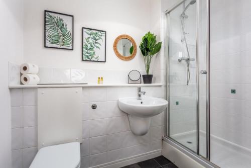 a white bathroom with a shower and a sink at Walker Suite No52 - Donnini Apartments in Kilmarnock
