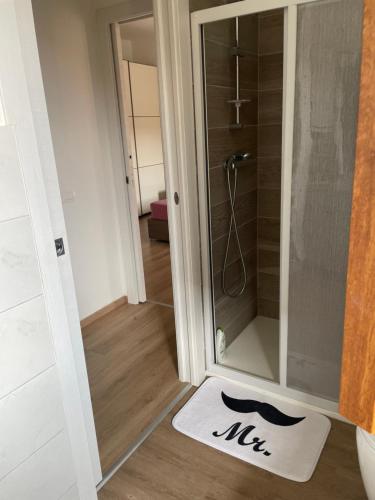 La salle de bains est pourvue d'une douche et d'un tapis blanc. dans l'établissement Il BORGHETTO-1, à Grazzano Badoglio
