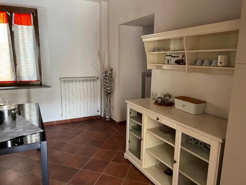 cocina con armarios blancos y suelo de baldosa en Il BORGHETTO-1 en Grazzano Badoglio