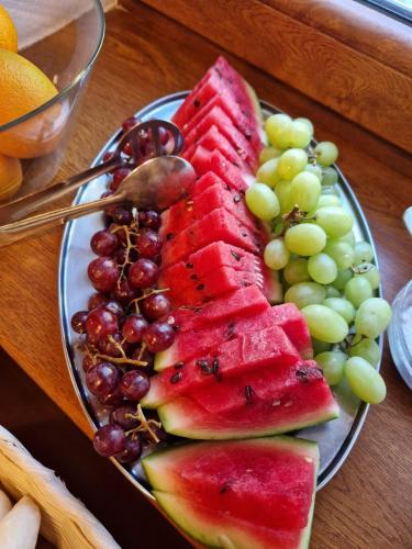 a plate of watermelon and grapes on a table at Horský Hotel Sněženka in Hynčice pod Sušinou
