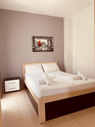 a bedroom with a large bed with white sheets at Villa Merkuri in Himare