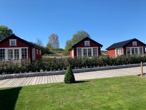 two red houses with a lawn in front of them at Lyxiga stugor med sjöutsikt in Söderköping