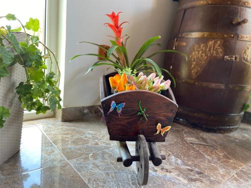 a wooden cart with a planter with flowers in it at Casa Maruska in Murighiol