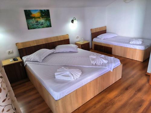 two beds in a room with wooden floors at Casa Maruska in Murighiol