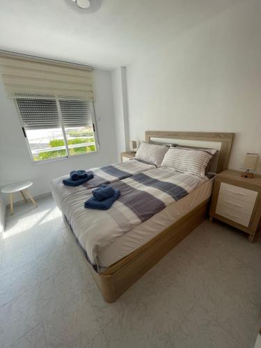 a bedroom with a large bed and a window at Casa de Perlas in El Campello