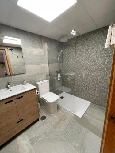 a bathroom with a toilet and a sink and a shower at Casa de Perlas in El Campello