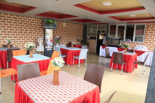 restauracja z czerwono-białymi stołami i krzesłami w obiekcie Jatheo Hotel Rwentondo w mieście Mbarara