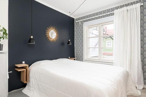a bedroom with a white bed and a window at Idyllic house in Old Rauma in Rauma