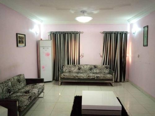 uma sala de estar com um sofá e um frigorífico em 1-bedroom apartment in dolphin em Lagos